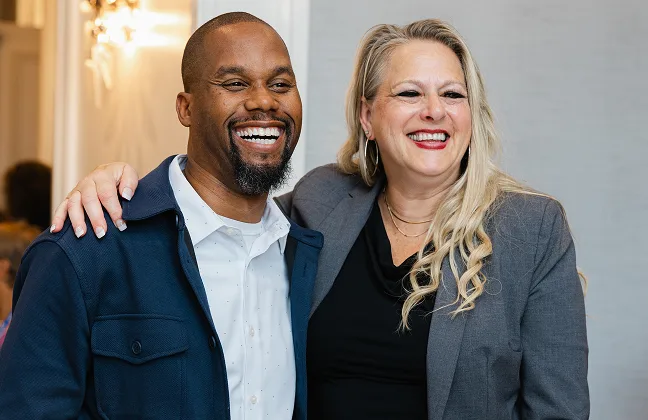 Two smiling colleagues pose together at a White Castle employee recognition event.